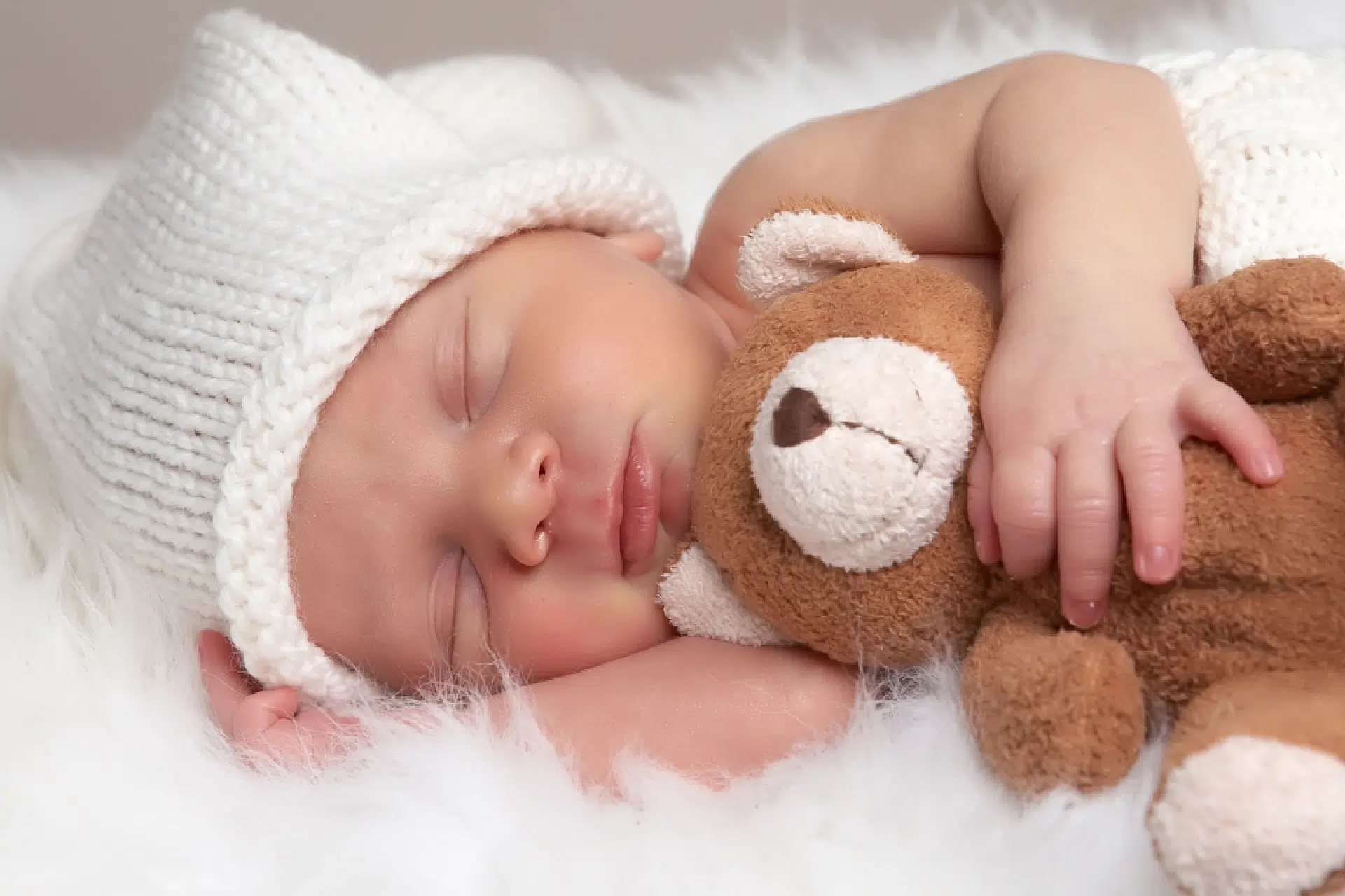Bébé dormant avec un ours en peluche