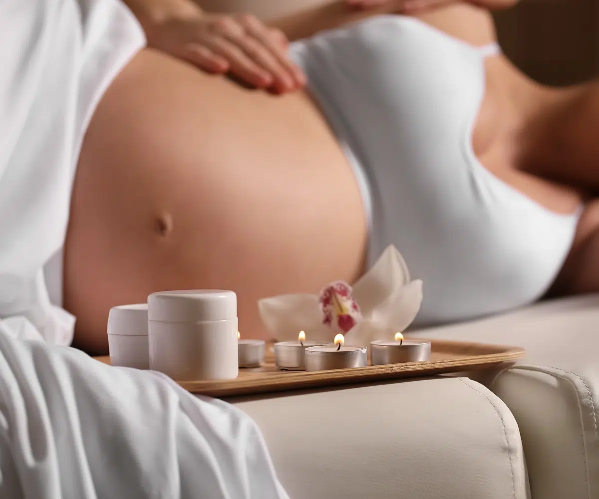Femme enceinte se relaxant avec des bougies