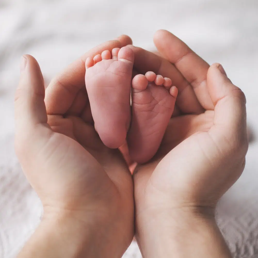 Pieds de bébé dans des mains